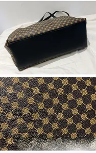 Detail of dark brown clover pattern fabric and black leather base with litchi texture