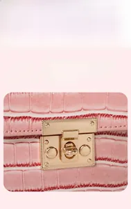 Close-up of golden metal clasp on a pink crocodile pattern leather handbag detail