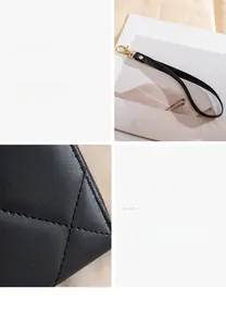 Detail of black quilted faux leather wallet with diamond stitching and wrist strap
