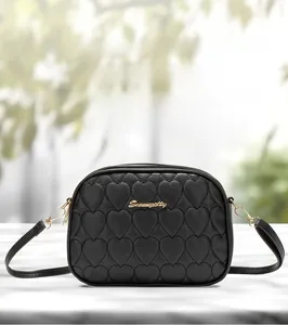 Detail of heart-quilted black PU leather camera bag with golden Sunnycity metal logo
