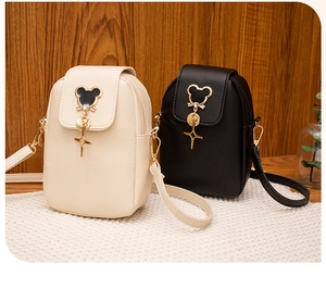 Close-up of beige and black mini phone bags with mouse head hardware and star pendants