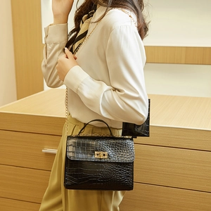 Black crocodile embossed handbag with gold chain strap and mini pouch on model