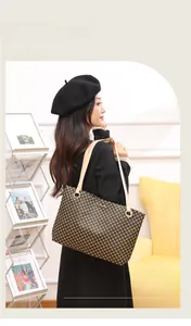 Détail du cabas à damier avec fines bandoulières en cuir beige porté à l'épaule