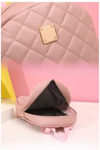 Dettaglio dello zaino trapuntato rosa con finiture dorate e ampio scomparto interno