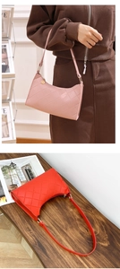 Detail of quilted leather shoulder bags in pink and red with diamond stitching pattern