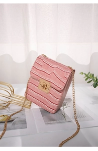 Detail of pink crocodile pattern small phone bag with glossy finish and gold chain
