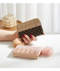 Detailed view of mini wallets featuring clover pattern, gold studs, and fuzzy pompom charm