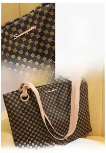 Détails d'un sac cabas marron à imprimé floral jaune et boucles en métal doré