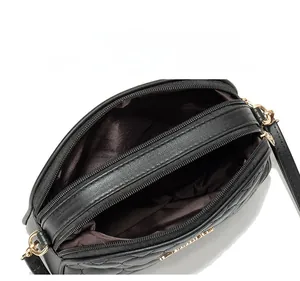Internal display of quilted crossbody bag showing dual zipper compartments and lining