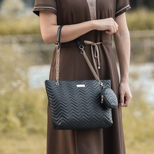 Elegant black quilted shoulder bag with V-shaped stitching and a gold chain strap
