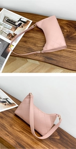 Detail of pink quilted shoulder bag with classic diamond stitching on leather surface