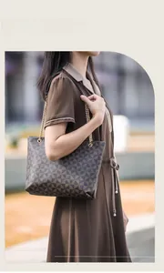 Détail d'un sac cabas à motif floral avec chaîne dorée porté par un mannequin