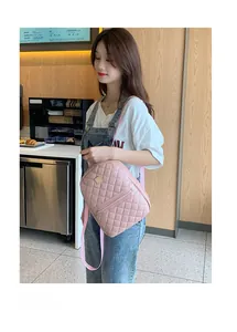 Dettaglio mini zaino trapuntato rosa con placca metallica dorata e tasca con zip