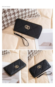 Detail of black quilted long wallet featuring gold chain decoration and wristlet strap