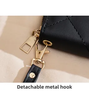 Macro shot of detachable golden metal hook and leather strap on embroidered wallet