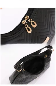 Detail of classic black quilted shoulder bag with golden zippers and chevron stitching