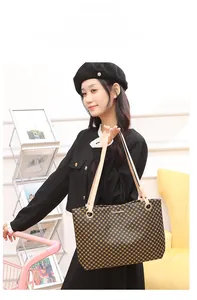 Détail du sac cabas à carreaux avec motif marron vintage et logo en métal poli