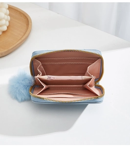 Detail view of mini light blue leather purse with card slots and inner pink lining