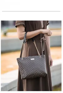 Détail du sac cabas à motif géométrique avec chaîne dorée et plaque logo métal
