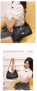 Detail of black quilted shoulder bag featuring golden zipper and V-shape stitching texture
