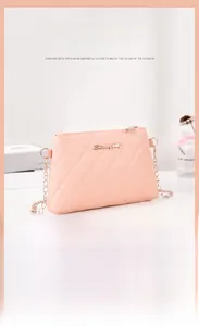 Detail of pink quilted handbag featuring gold logo and chain strap on desktop