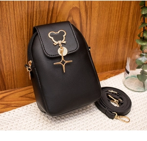 Detail of black faux leather phone bag with gold mouse clasp and star charm detail
