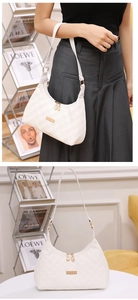 Detailed view of white quilted shoulder bag with gold hardware and elegant chain strap