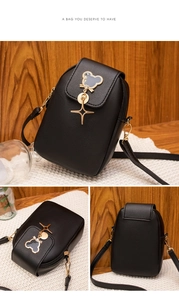 Detail view of black mini crossbody phone bag with gold mouse hardware and star charm