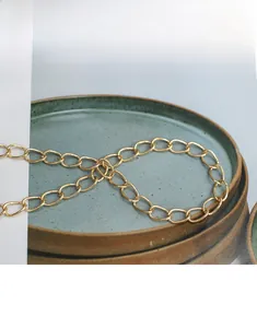 Close-up of golden metal chain shoulder strap for women crossbody bag with oval links