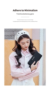 Detail of a black leather long wallet with silver logo held by a fashion model