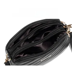 Internal display of black quilted bag with three large compartments and gold zippers
