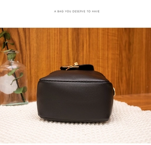 Detail view of the black leather bag bottom with golden hardware and neat stitching