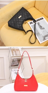 Detail of black quilted and red wavy textured shoulder bags with gold zippers