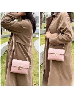Detailed view of pink quilted texture and gold metal lock on the elegant chain bag