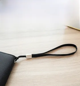Detail of lychee pattern leather long wallet with wrist strap and silver metal hardware