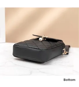 Detailed bottom view of black quilted PU leather mini bag with gold hardware accents