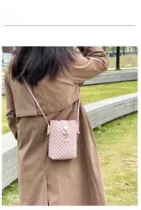 Outdoor model show of a pink printed crossbody phone bag with pearl pendant detail