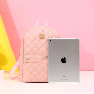 Mini zaino rosa trapuntato da donna accanto a un iPad per il confronto delle taglie