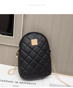Close-up of black quilted mini phone bag with gold metal square and chain strap