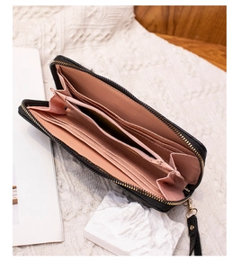 Detailed view of women's long zipper wallet showing multiple card slots and pink lining