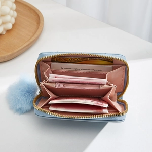 Sky blue quilted mini wallet with pompom charm and multi-slot pink interior