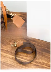 Detail of premium hardware clasp and nylon shoulder strap with leather trim on handbag