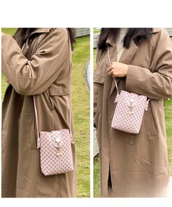 Pink printed crossbody phone bag with pearl pendant and cat ear buckle detail