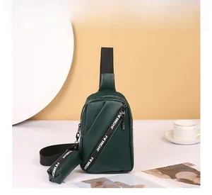 Detail of dark green leather chest bag with a mini pouch and branded decorative strap