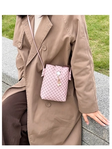 Detailed view of a pink crossbody phone bag with floral pattern and pearl cat charm