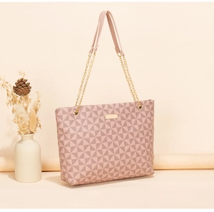 Gros plan d'un grand sac cabas rose clair avec motifs géométriques et chaîne dorée