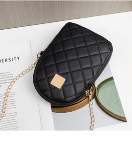 Close-up of black quilted cell phone bag with gold hardware and chain strap