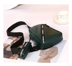 Detail of dark green crossbody bag with small coin purse and wide woven logo strap
