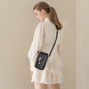 Quilted crossbody phone bag in black with gold crown pendant and pearl charm