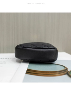 Detailed view of the diamond-quilted stitching and base width of the black shoulder bag